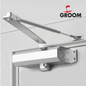 Ferme-porte groom argent avec bras compas hydraulique, capacité 60kg, finition professionnelle"
"Vue détaillée du mécanisme hydraulique du 
"Installation du ferme-porte groom argent sur porte d'entrée, bras compas visible